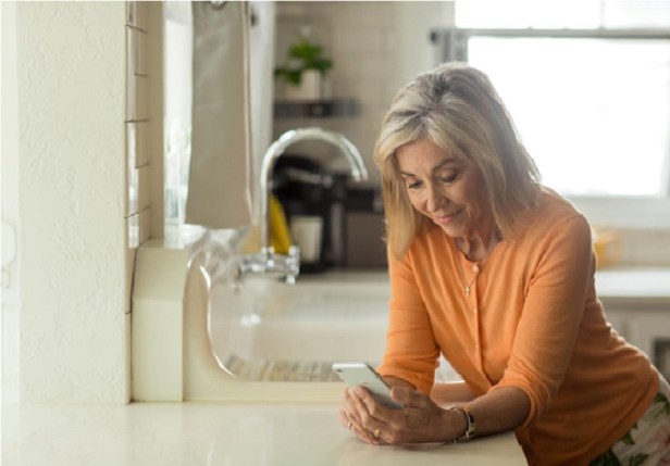 A picture of a woman meeting with her doctor on her phone in the comfort of her home
