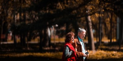 A picture of an older couple walking in the park after recovery from TKA surgery with the help of ROM Technologies’ PortableConnect device